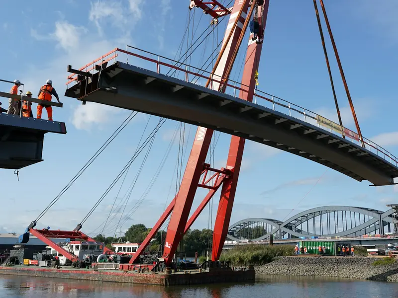 Stock photo: crane lifting a steel bridge section into place during civil works