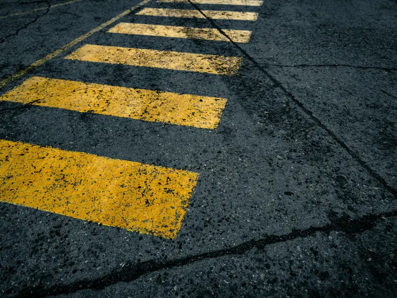 Stock photo: freshly painted yellow pedestrian crossing (zebra) road markings on asphalt